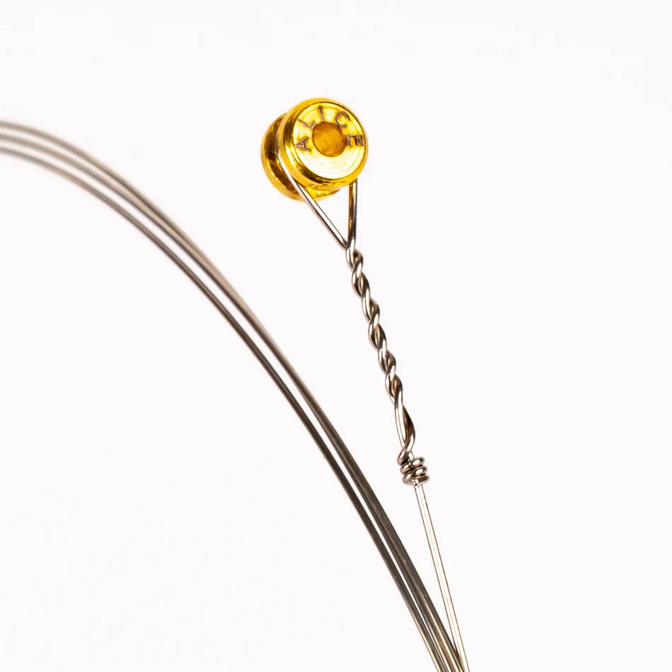 A close-up of a single light gauge electric guitar string with a gold-colored tuning post.