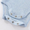 Light blue ribbed cotton baby bodysuit with long sleeves folded and displayed