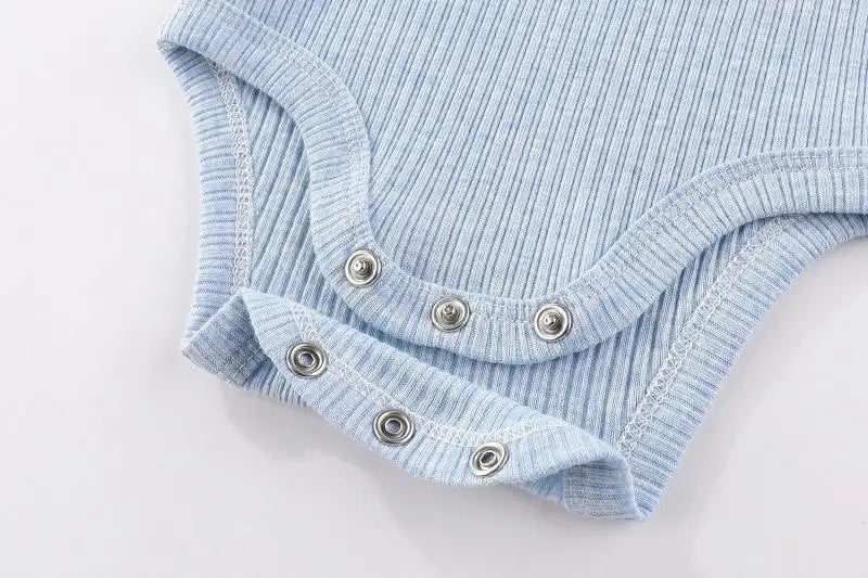 Light blue ribbed cotton baby bodysuit with long sleeves folded and displayed