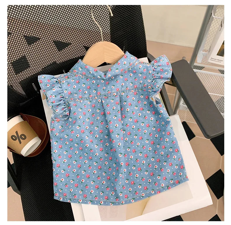 A light blue floral print girls' sleeveless shirt and shorts set displayed on a white surface.