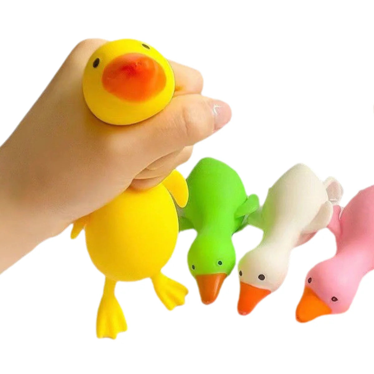 A hand is squeezing a yellow plastic duck toy with an orange beak and green accents.