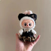 A plush doll dressed in a leopard print sling dress with white fur trim and black accents.