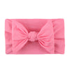 Un bandeau élastique rose doux noué en nœud, plié proprement.