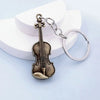 A vintage-style violin charm attached to a silver keyring.