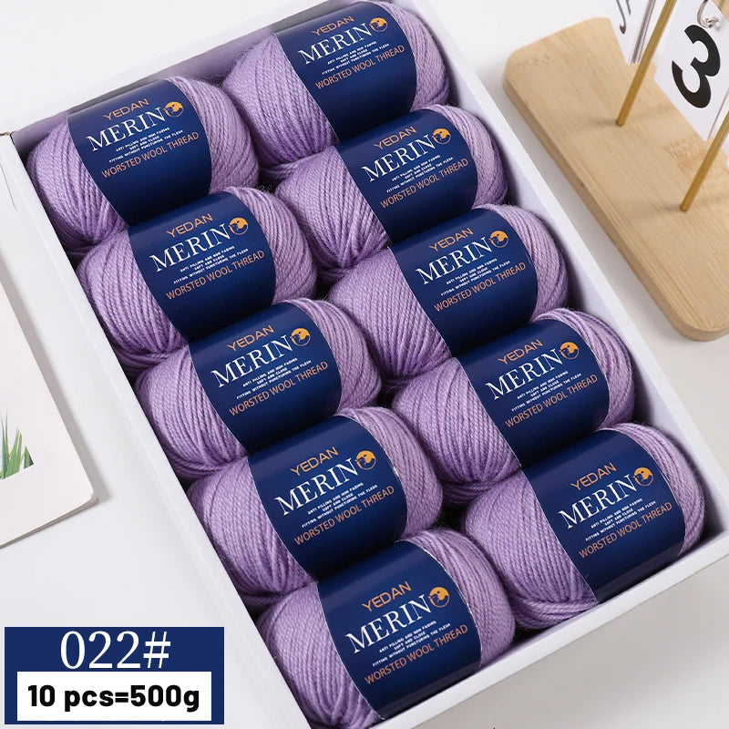 A box of YEDAN MERIN worsted wool thread yarn in purple and blue colors for knitting projects.