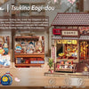 A detailed wooden dollhouse featuring a traditional Japanese style building with an open shop and intricate details.