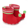 A pair of red baby first walker shoes with green trim and a festive pattern.