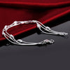 Elegant sterling silver snake chain bracelet for women displayed on a dark surface against a red fabric background