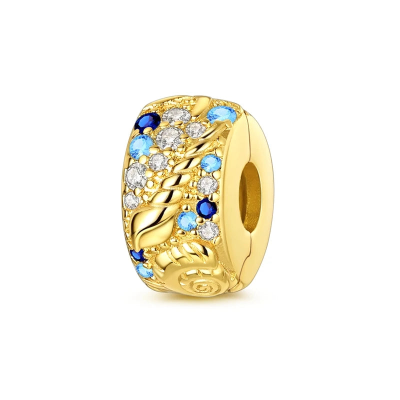Gold-toned charm pendant featuring a swirling design with blue and clear gemstones.