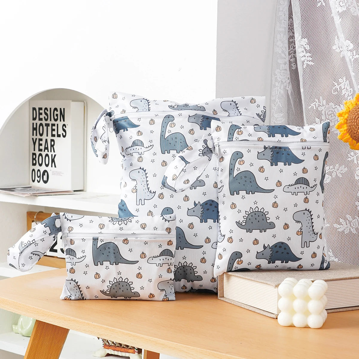 A pack of three waterproof wet and dry bags featuring dinosaur patterns for swimsuits, diapers, and travel items.