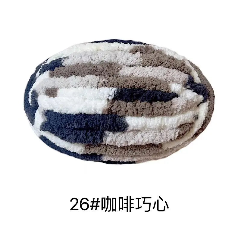 A ball of chunky chenille yarn with a mottled pattern of gray, white, and dark blue.