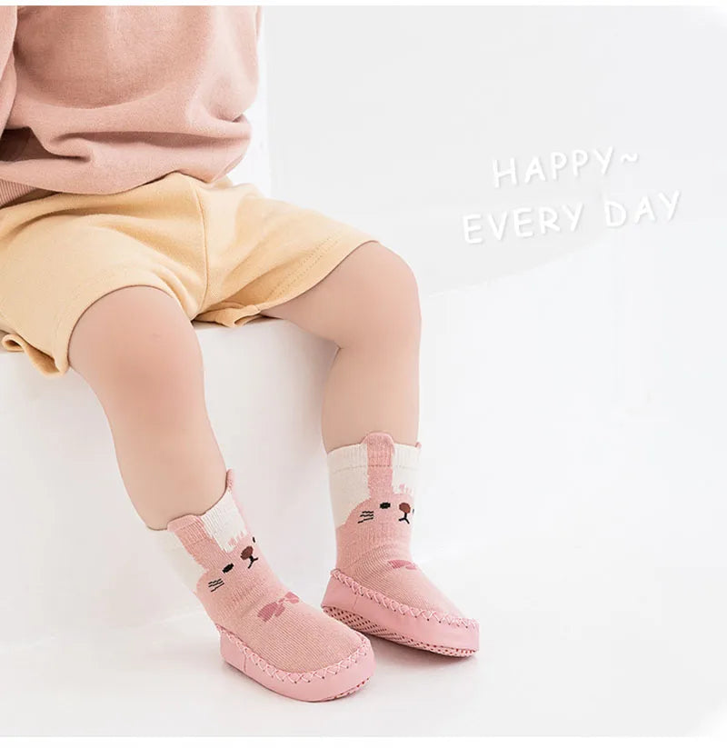 Pink cartoon animal non-slip socks for babies and toddlers shown on a child's foot.