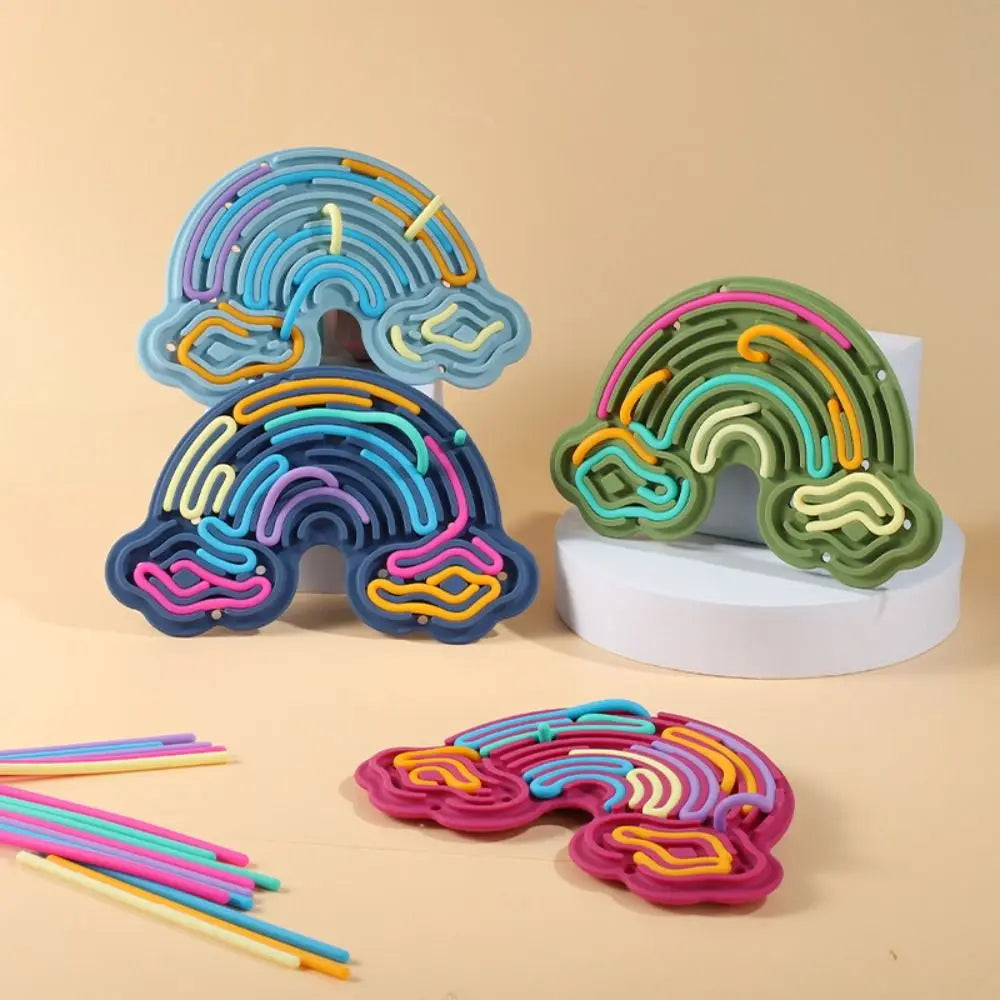 Colorful silicone sensory activity boards with strings in blue, green, and pink on a white stand.
