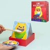 A wooden bear feeding game toy with a wooden spoon and food items is shown next to its packaging box.