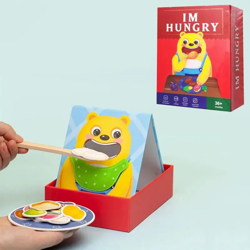 A wooden bear feeding game toy with a wooden spoon and food items is shown next to its packaging box.
