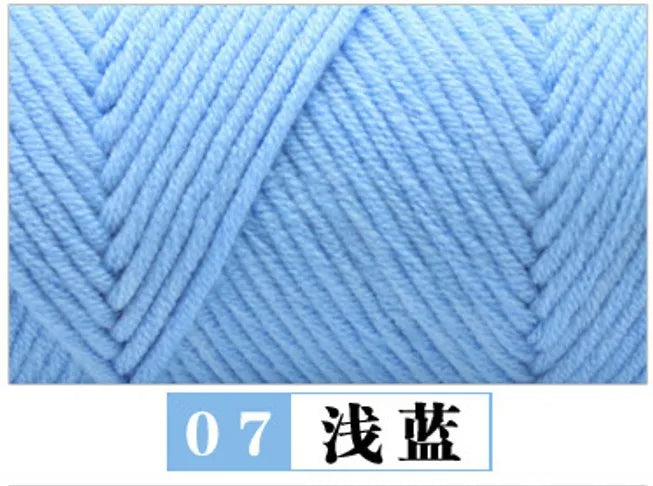 A close-up view of light blue premium milk cotton yarn showing a diagonal knit pattern.