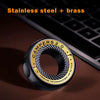A black magnetic fidget ring labeled Campers 2.0 made of stainless steel and brass resting on a dark surface.