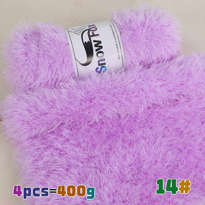 Purple chunky faux fur yarn in a skein with a purple knitted item visible.