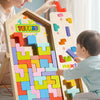 A child and an adult are playing with a wooden Tetris-style geometric shape puzzle.