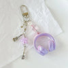 A silver phone lanyard keychain featuring a beaded wing charm and a purple silicone headset ring.