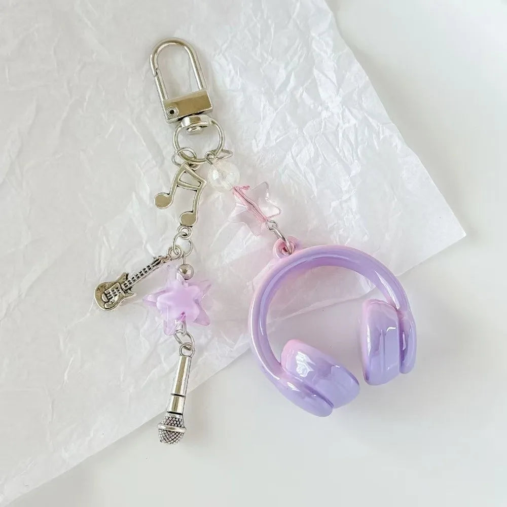A silver phone lanyard keychain featuring a beaded wing charm and a purple silicone headset ring.