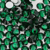 A close-up view of small, faceted green and black glass crystals or rhinestones.