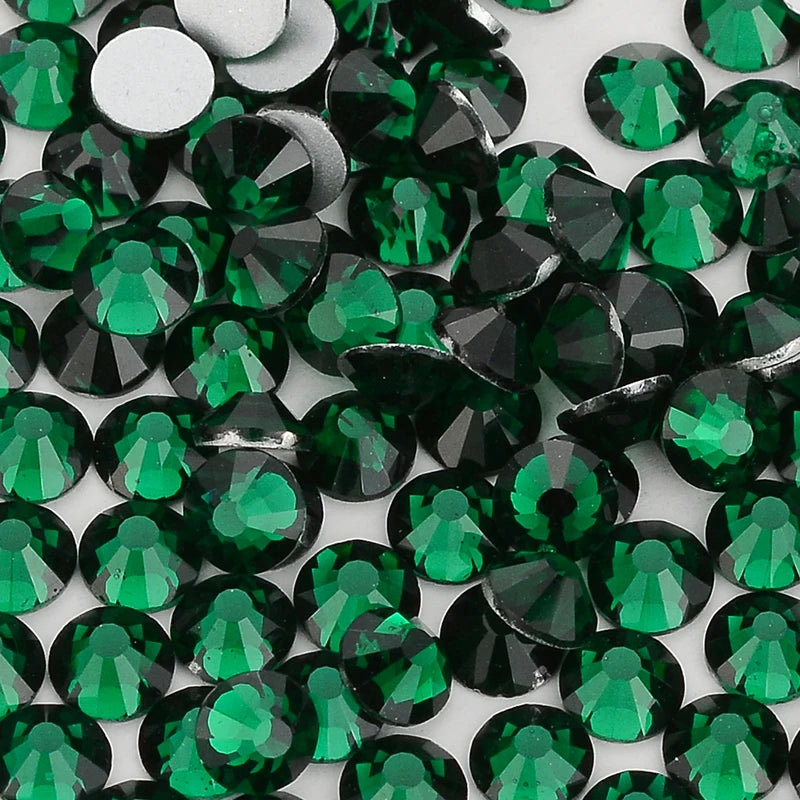 A close-up view of small, faceted green and black glass crystals or rhinestones.