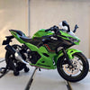 A green Kawasaki Ninja diecast model motorcycle with black accents displayed on a stand.