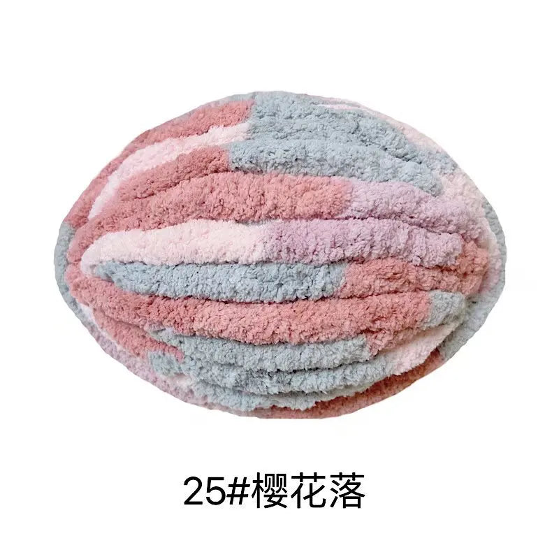 A ball of pink and blue chunky chenille yarn for hand knitting projects.