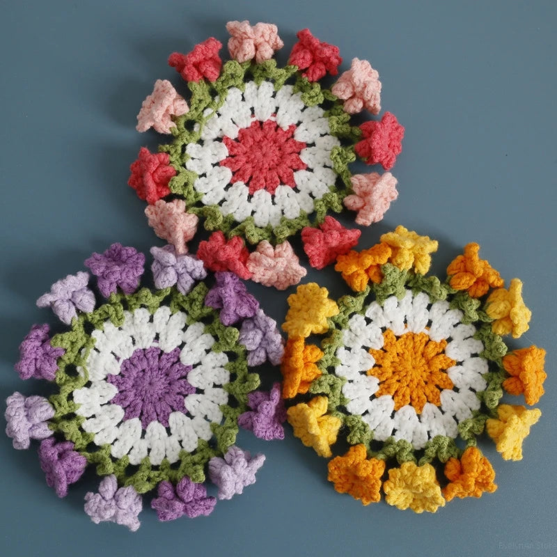 Hand-crocheted lily of the valley coasters featuring colorful floral patterns in pink, white, purple, and orange.