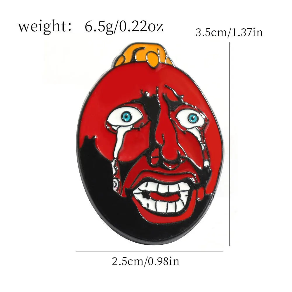 A red enamel lapel pin depicting a demonic face with glowing blue eyes and dripping blood.