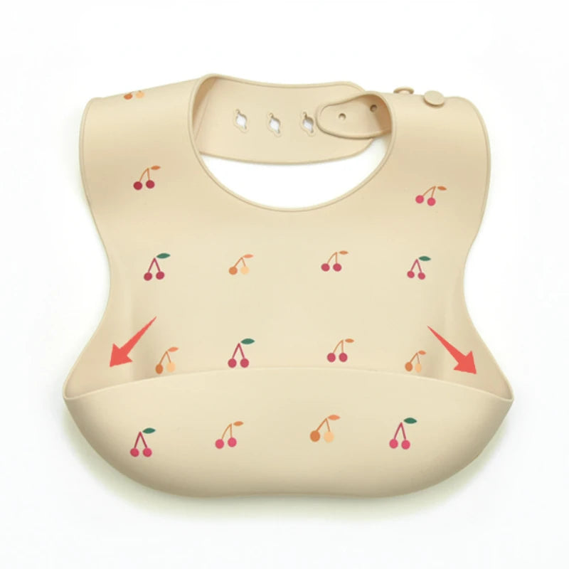 A beige soft silicone waterproof baby bib with an adjustable neck and small fruit illustrations.