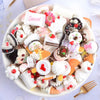 A bowl filled with assorted white and pink candy resin flatbacks for DIY crafts and jewelry making