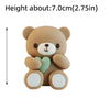 A light brown 3D bear cake topper with a green heart detail.