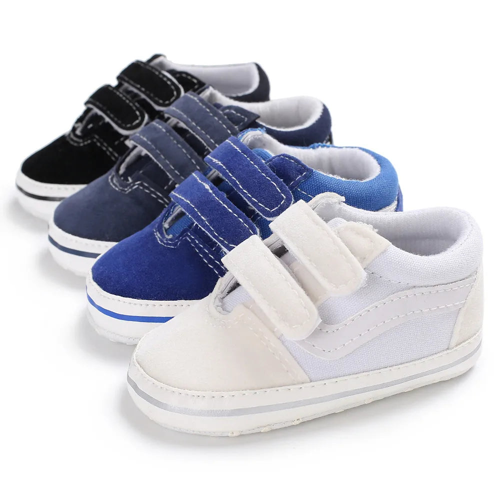 A row of blue and gray canvas baby sneakers for infants, showing various colors and styles.