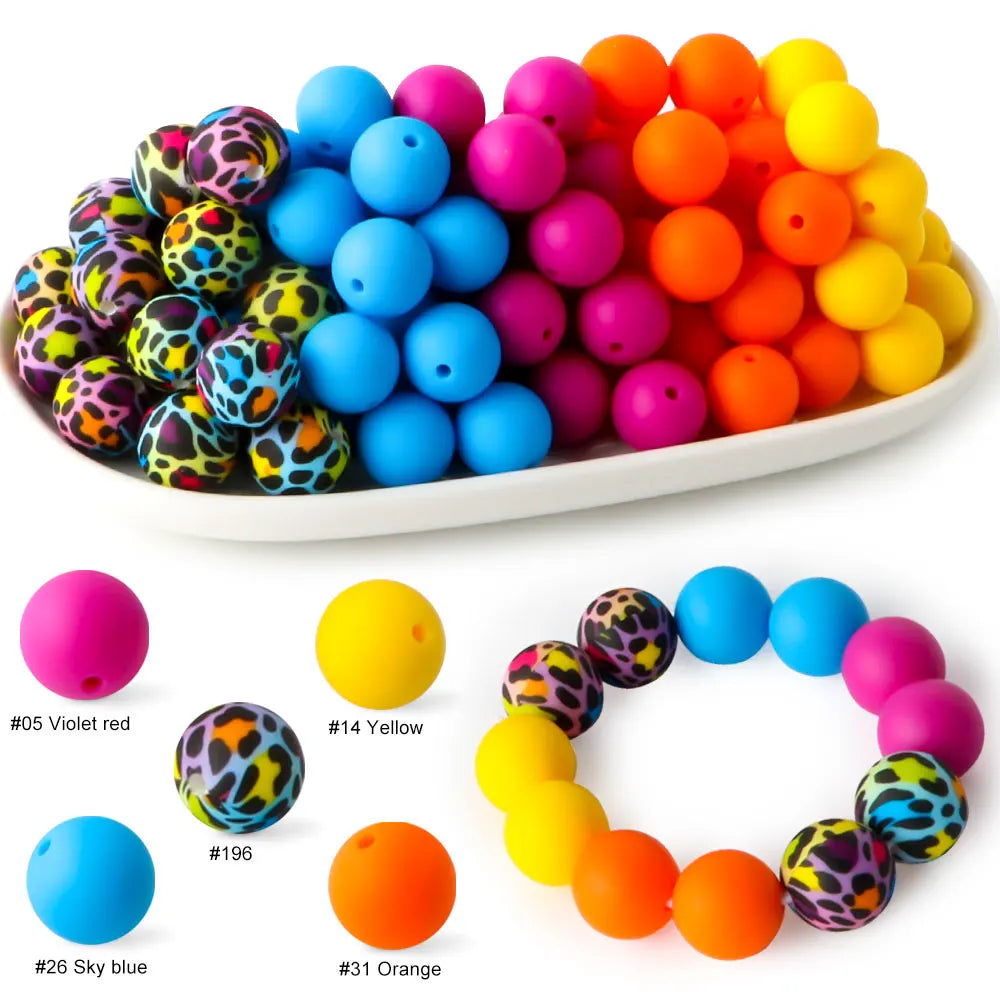 A variety of colorful silicone beads in various shapes and colors are displayed on a white plate.
