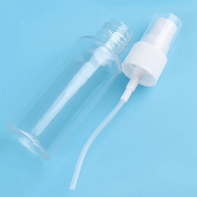 A clear glass bottle with a white fine mist pump dispenser is shown against a light blue background.
