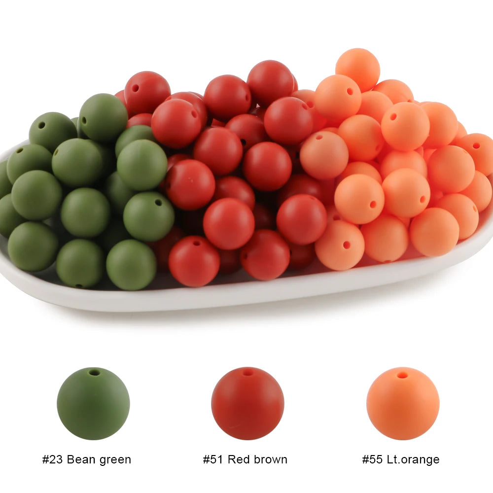 A bowl filled with round silicone beads in green, red brown, and light orange colors.