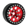 A close-up view of a black metal beadlock wheel with a red center and removable hex hub.