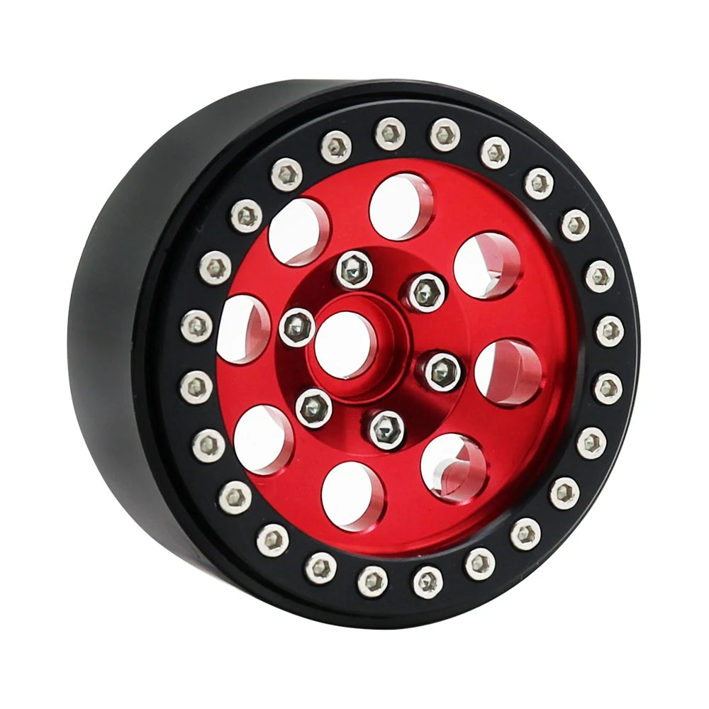 A close-up view of a black metal beadlock wheel with a red center and removable hex hub.