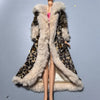 A fashion doll wearing a long coat with a brown leopard print and light fur trim.