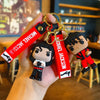 A hand holds a Michael Jackson Dance Pose keychain with a gold split ring and red tag.