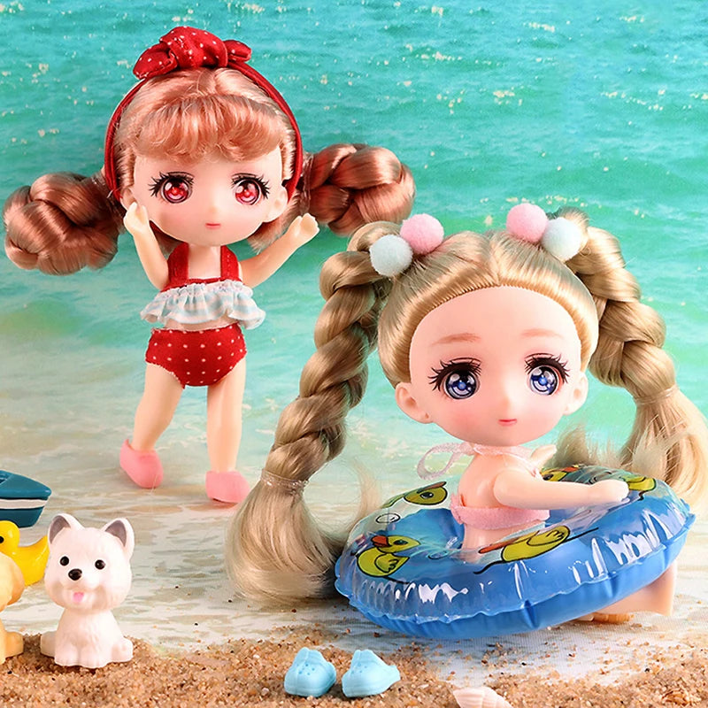 A small doll with pink hair and red bow is shown next to a blue inflatable ring on a sandy surface.