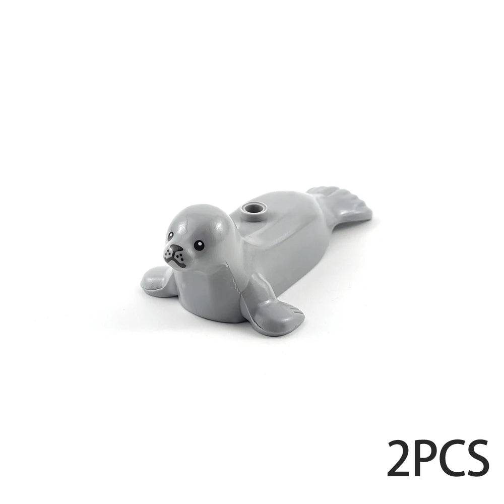 A pair of gray ocean animal building blocks, resembling seals or sea creatures.