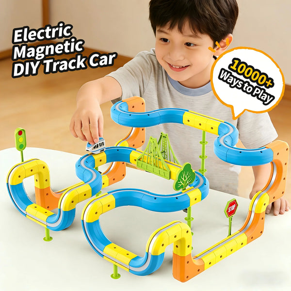 A young boy is playing with an orange and blue magnetic DIY track car building set on a white table.