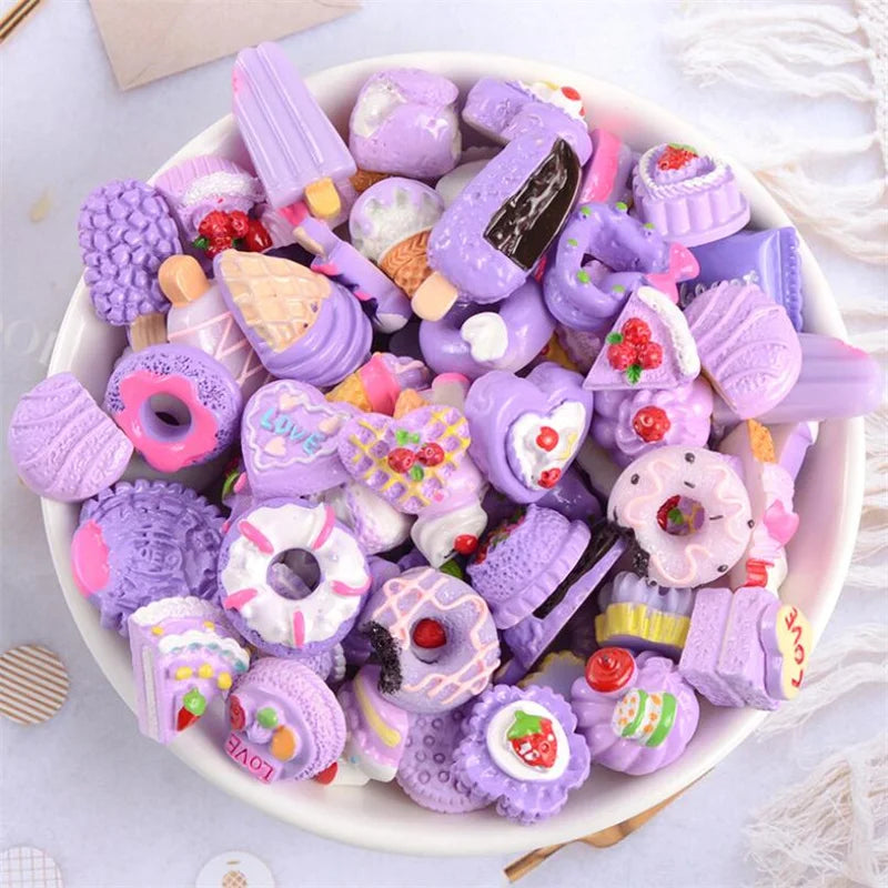 A bowl filled with assorted purple and pink candy resin flatbacks for DIY crafts and jewelry making