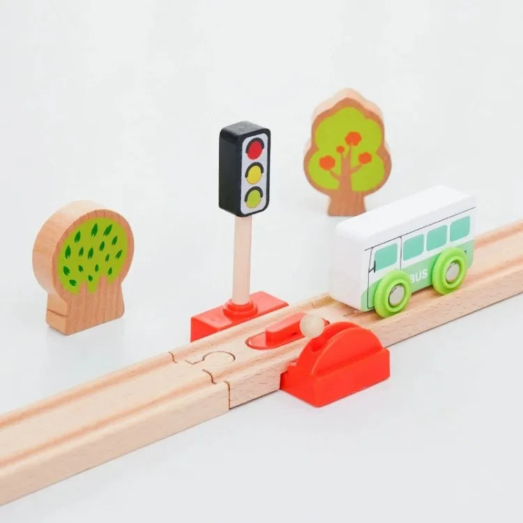 A wooden train track accessory set featuring a signal light, a tree shape, and a green train car.