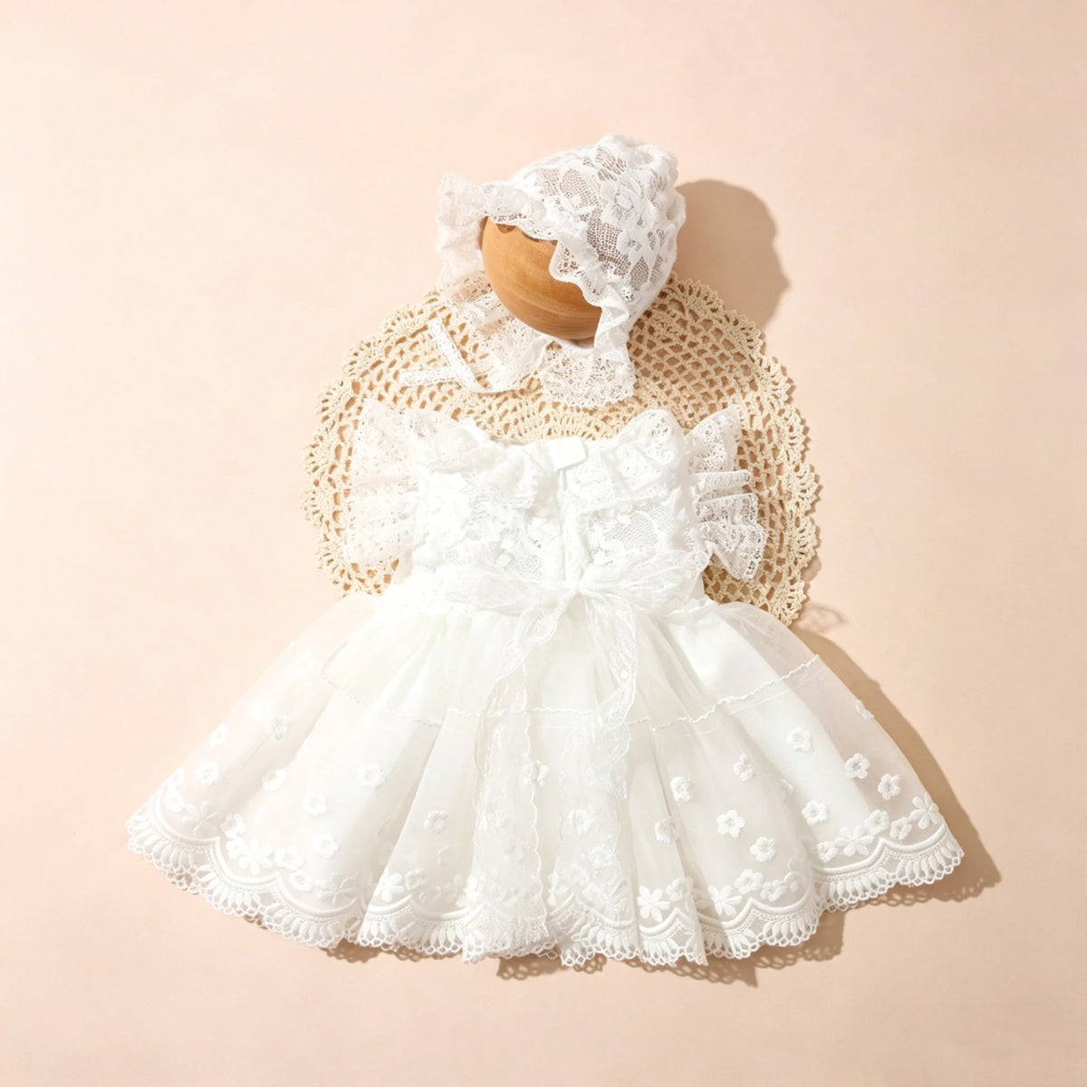 A white lace tulle dress for a newborn baby girl with a matching lace bonnet, displayed on a light background.