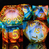 A set of polyhedral dice with a galaxy finish, showing various colors and angles on a reflective surface.