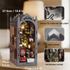 A wooden book nook kit featuring an intricate scene with LED lights and a dust cover.